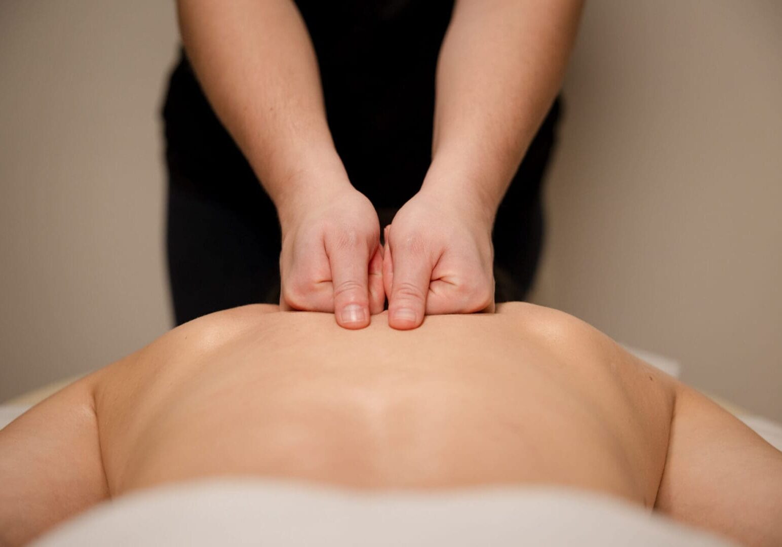 Therapist performing a lower back massage with oil. Relaxation and pain relief concept The Foot Spa